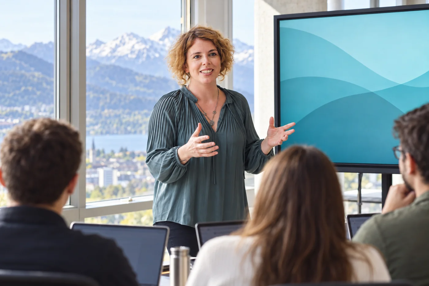 Stefanie Gründler erklärt in einem hellen Kursraum, Teilnehmende arbeiten an Laptops